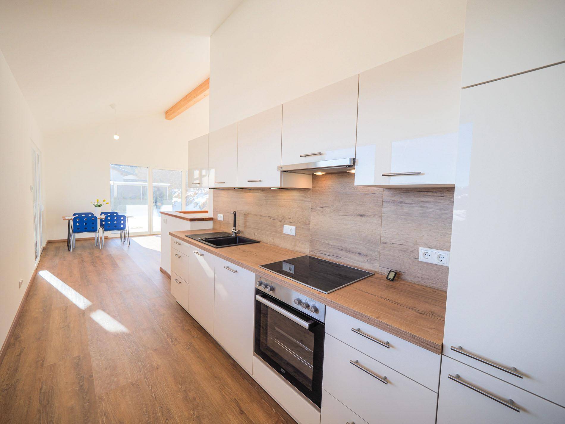 Helle, moderne Küche mit weißen Schränken, Holzarbeitsplatten und offenem Essbereich.