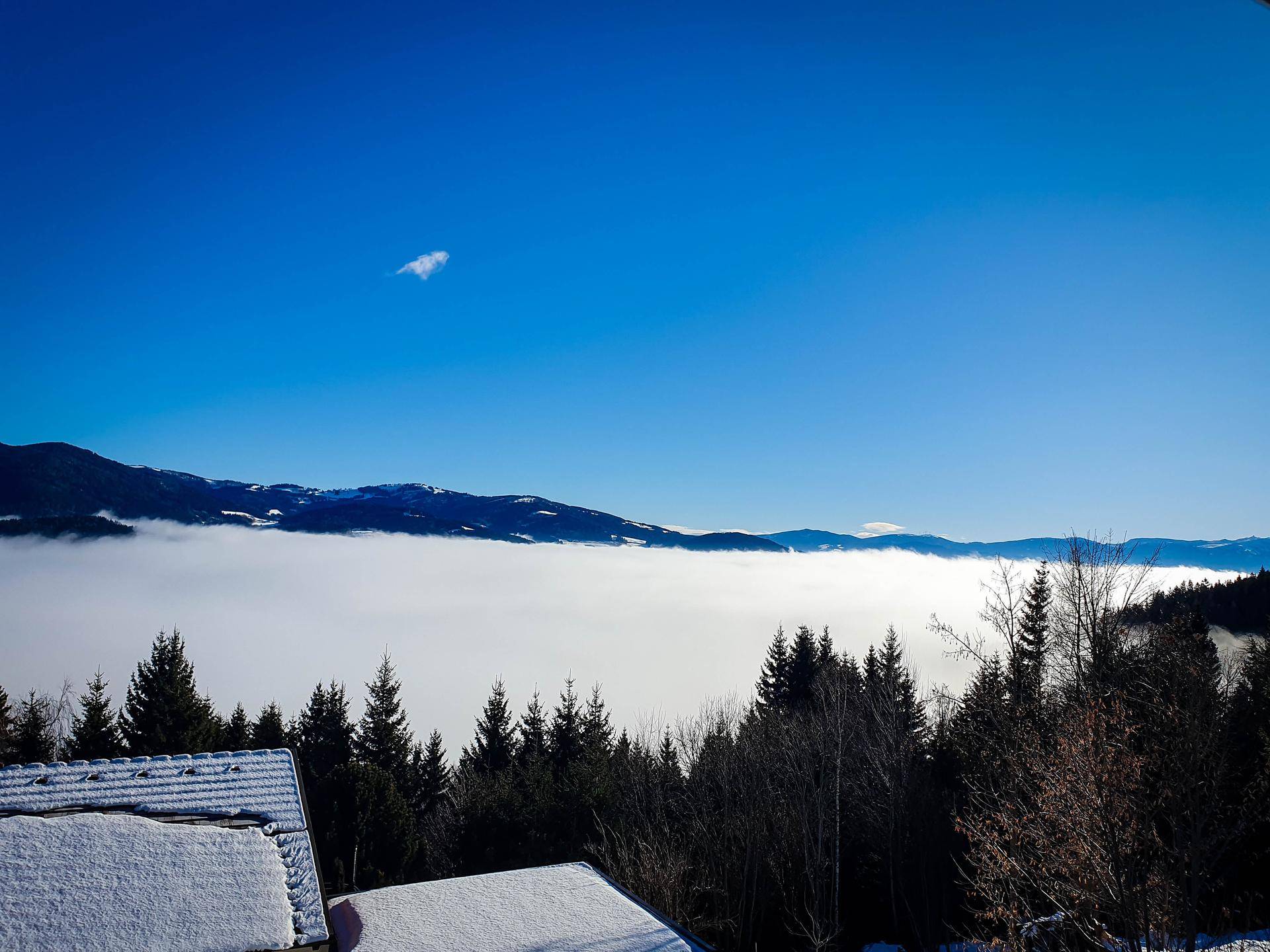 Atemberaubender Blick auf Berggipfel, die aus einem Wolkenmeer herausragen.