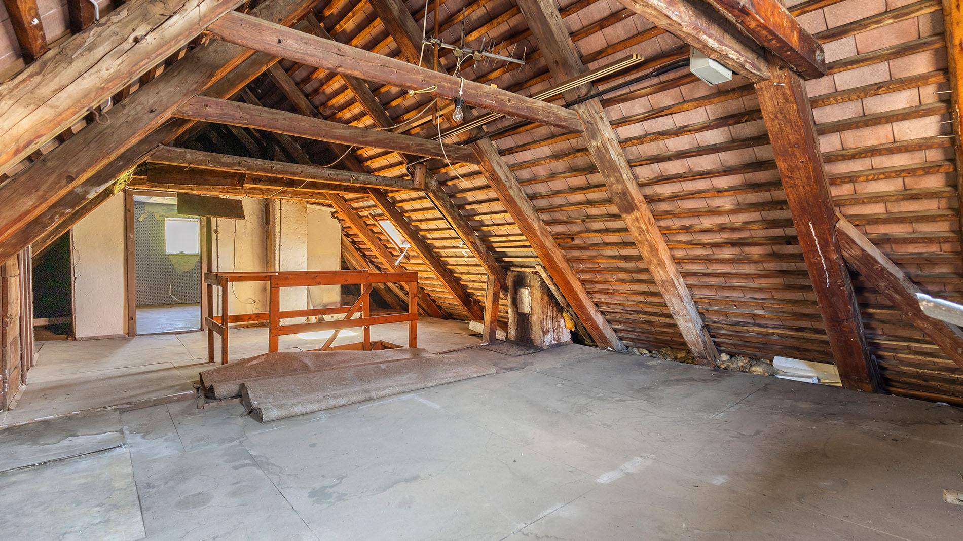 Geräumiger Dachboden mit sichtbaren Holzbalken und Ausbaupotenzial.