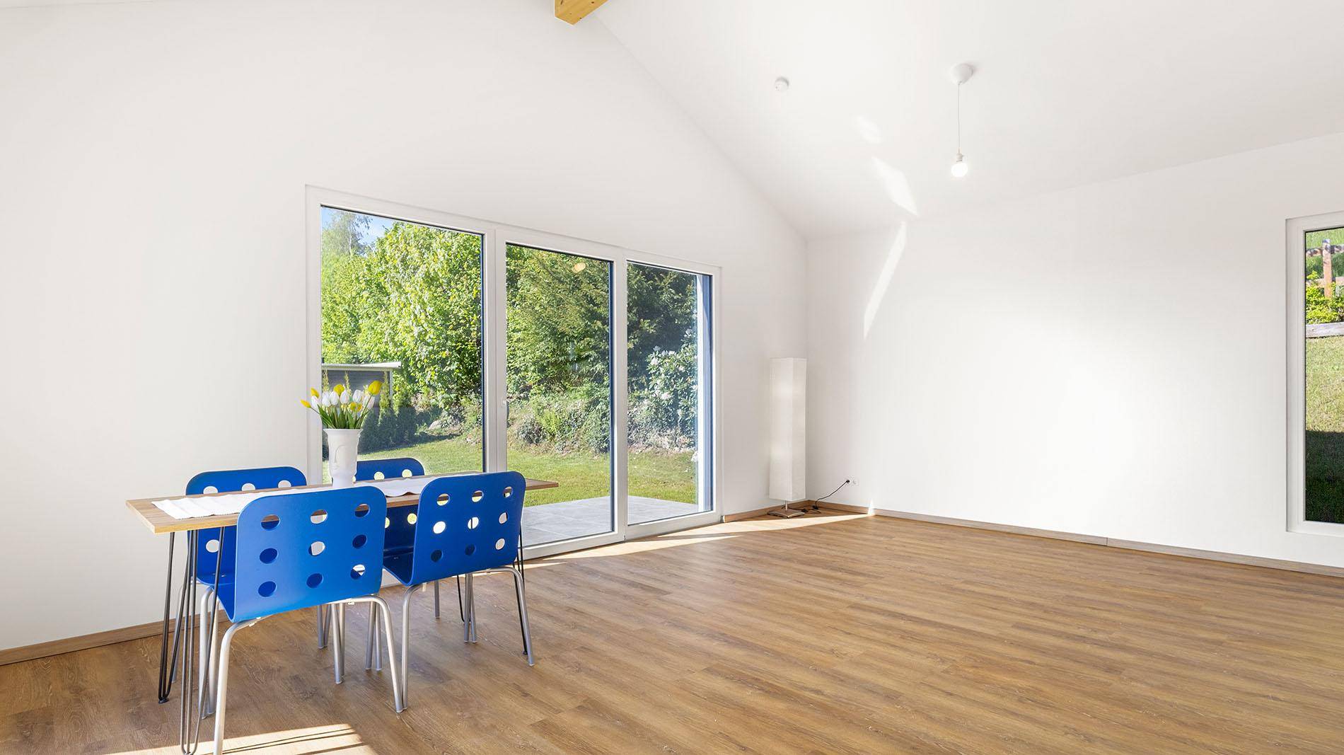 Geräumiger Wohnbereich mit Laminatboden, Essbereich und Zugang zum Garten.