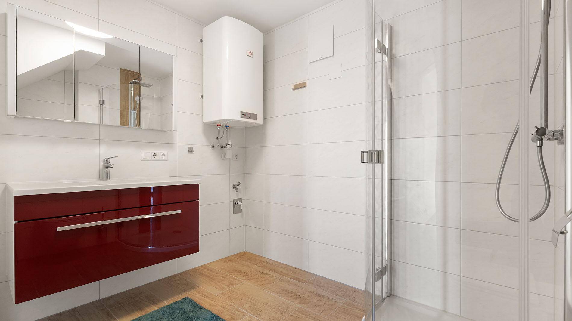 Modernes Badezimmer mit Waschtisch, Spiegelschrank und Duschkabine.