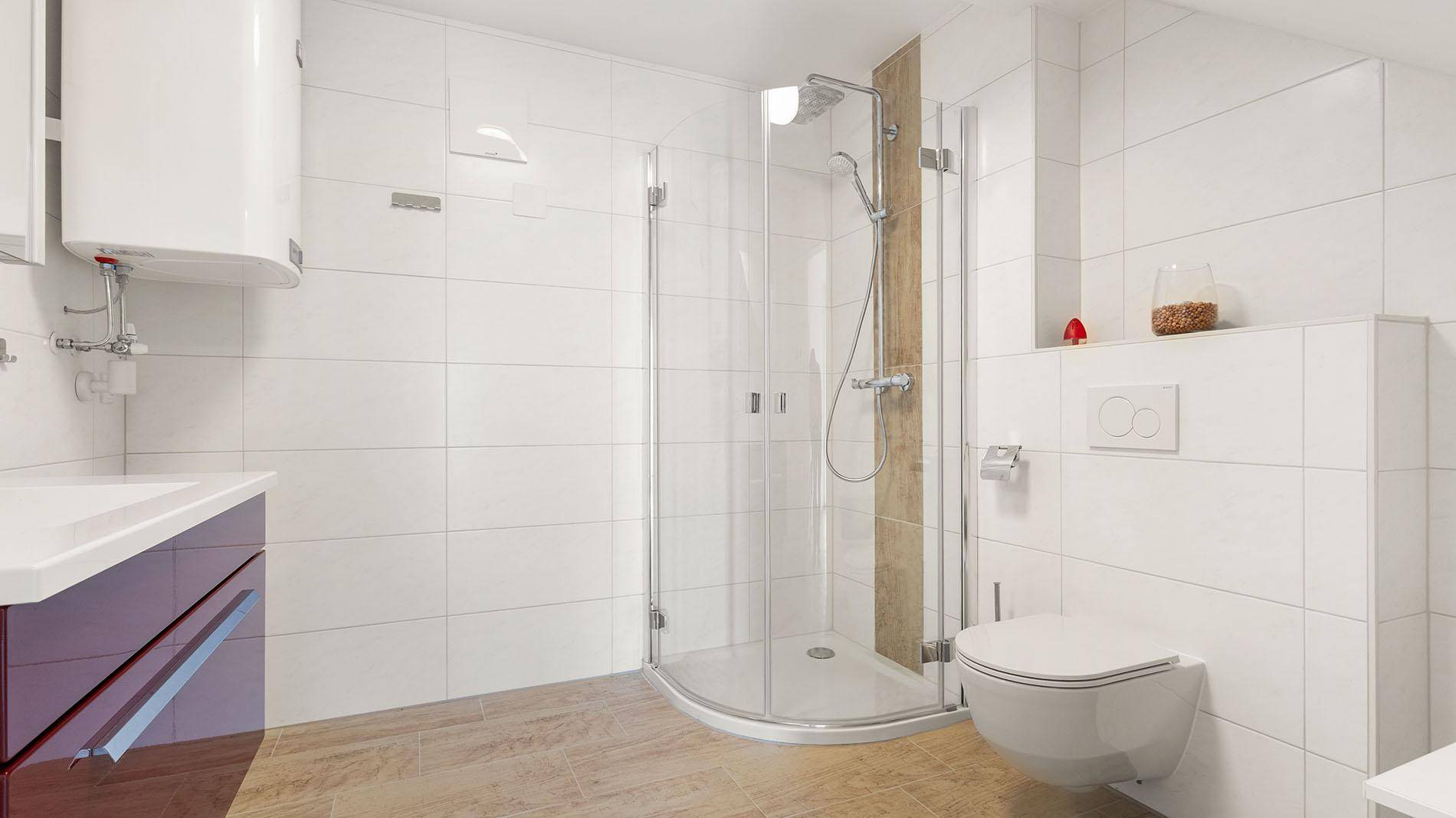 Helles Badezimmer mit Dusche, WC und modernen Fliesen an den Wänden.