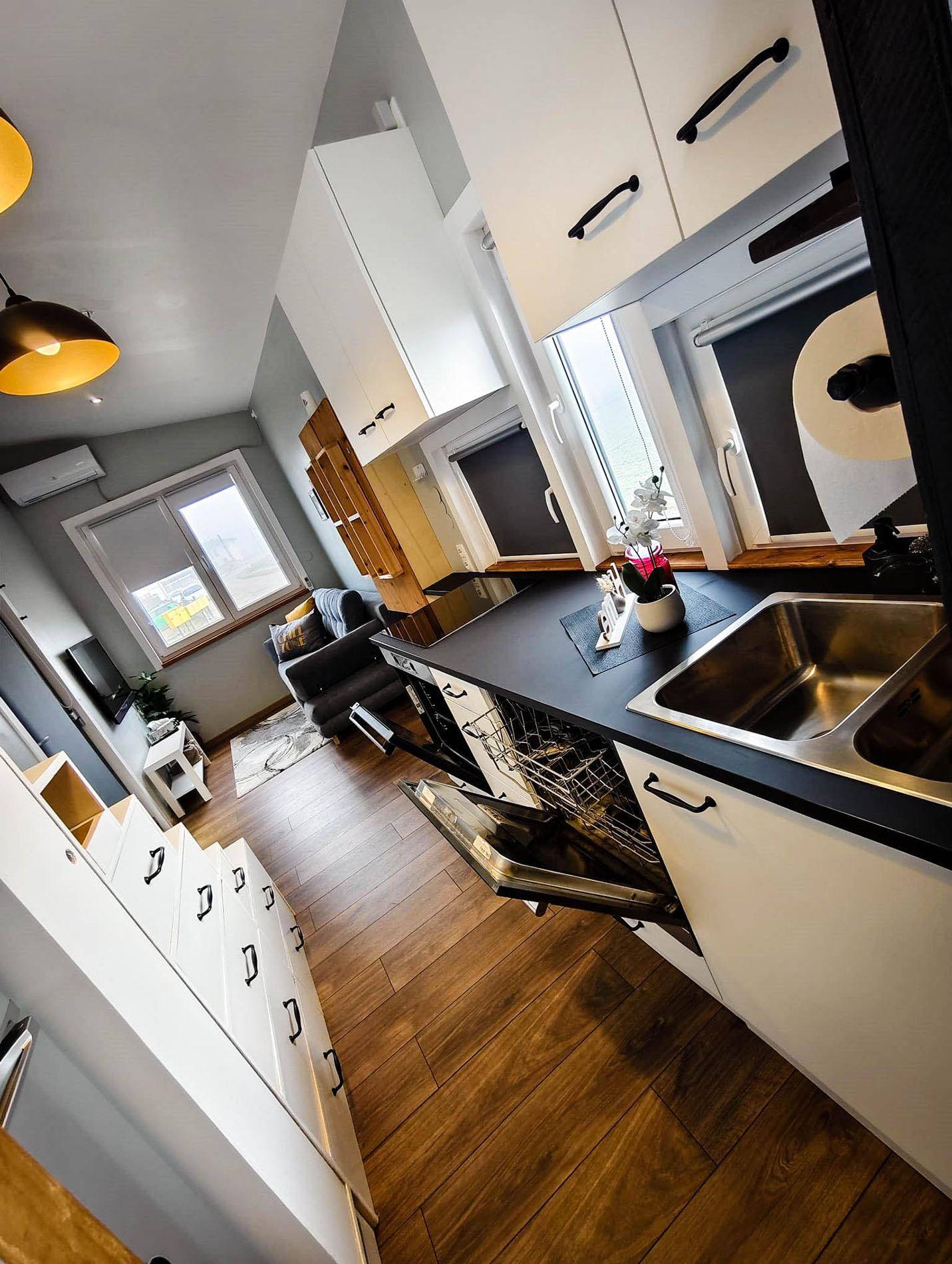 Funktionale Küchenzeile mit Spüle, Geschirrspüler und Stauraum im Tiny House.