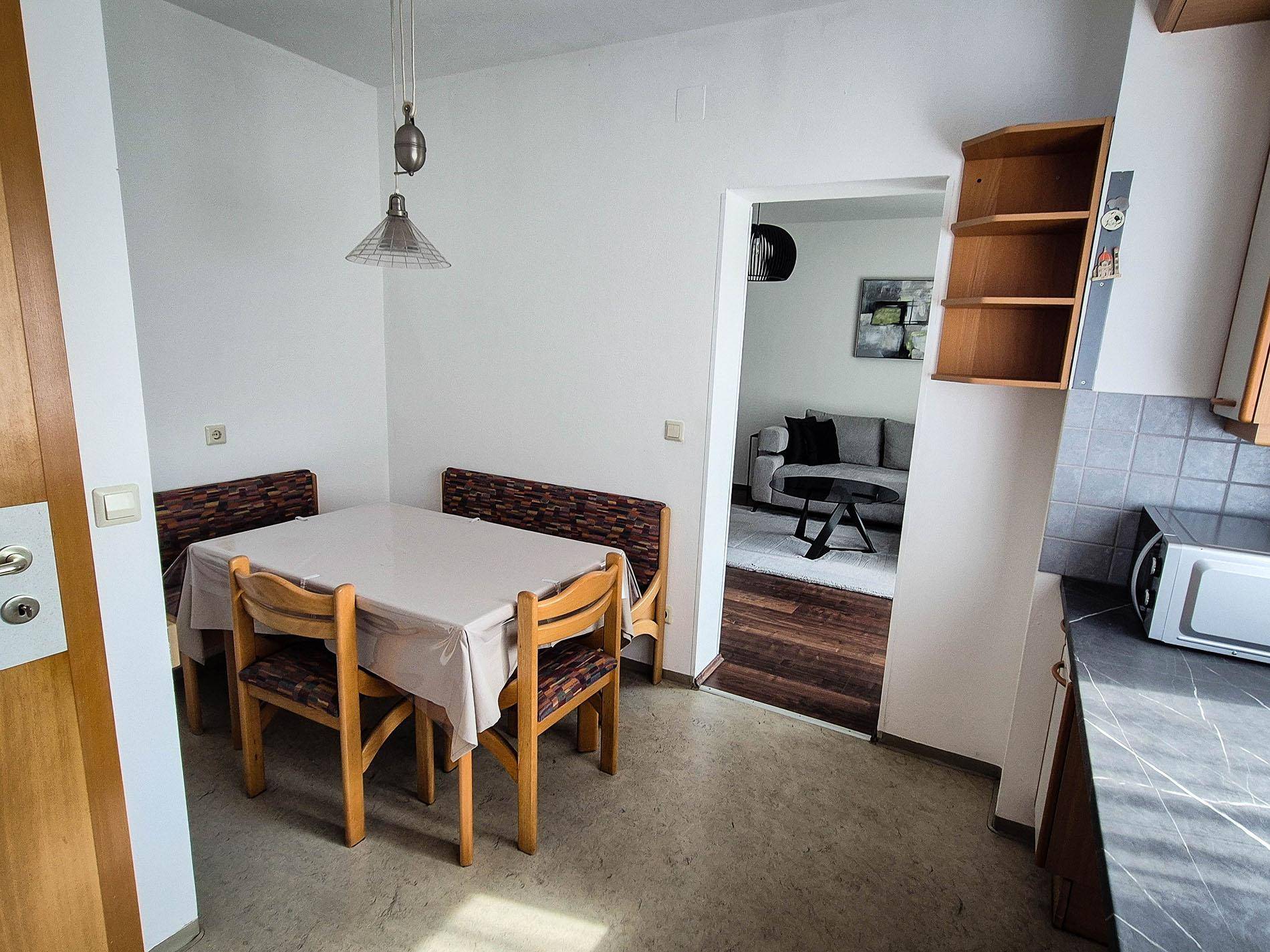 Essbereich in der Küche mit Tisch und Sitzbank, angrenzend an das Wohnzimmer.