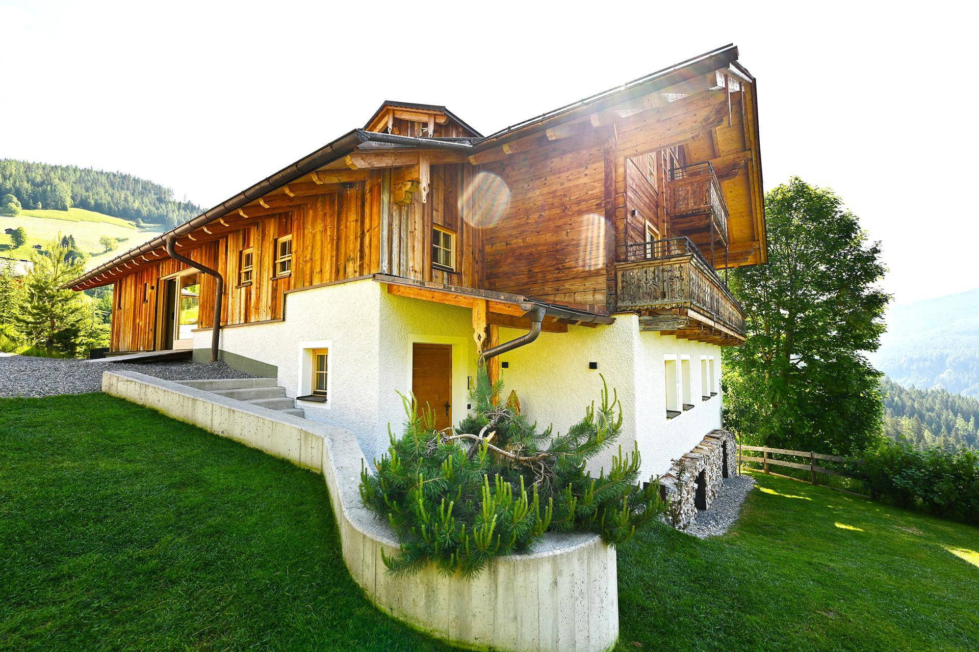 Alpines Chalet mit moderner Architektur und traditionellen Holzelementen, umgeben von Natur.