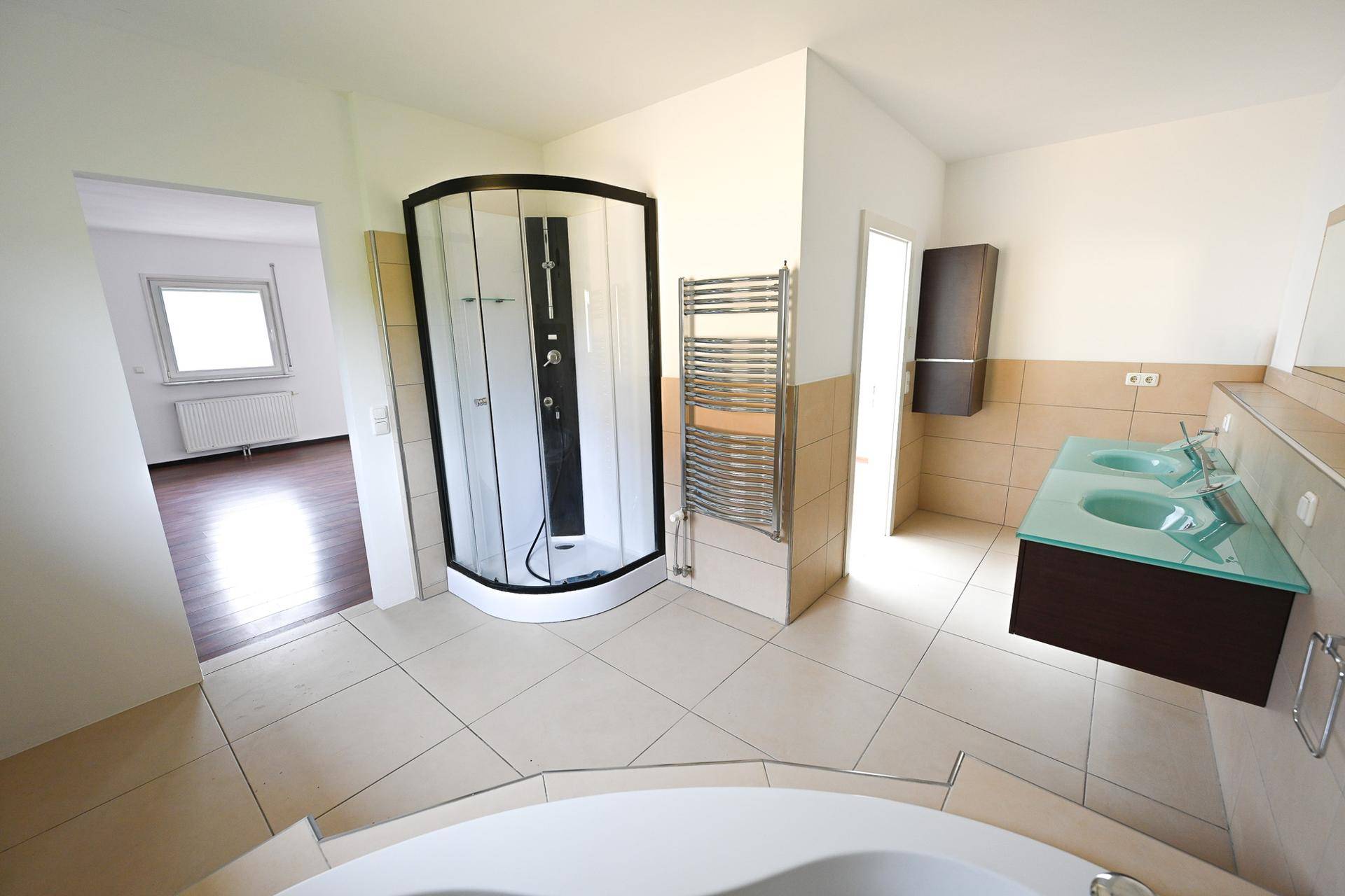 Geräumiges Badezimmer mit Dusche, Badewanne und Doppelwaschbecken.