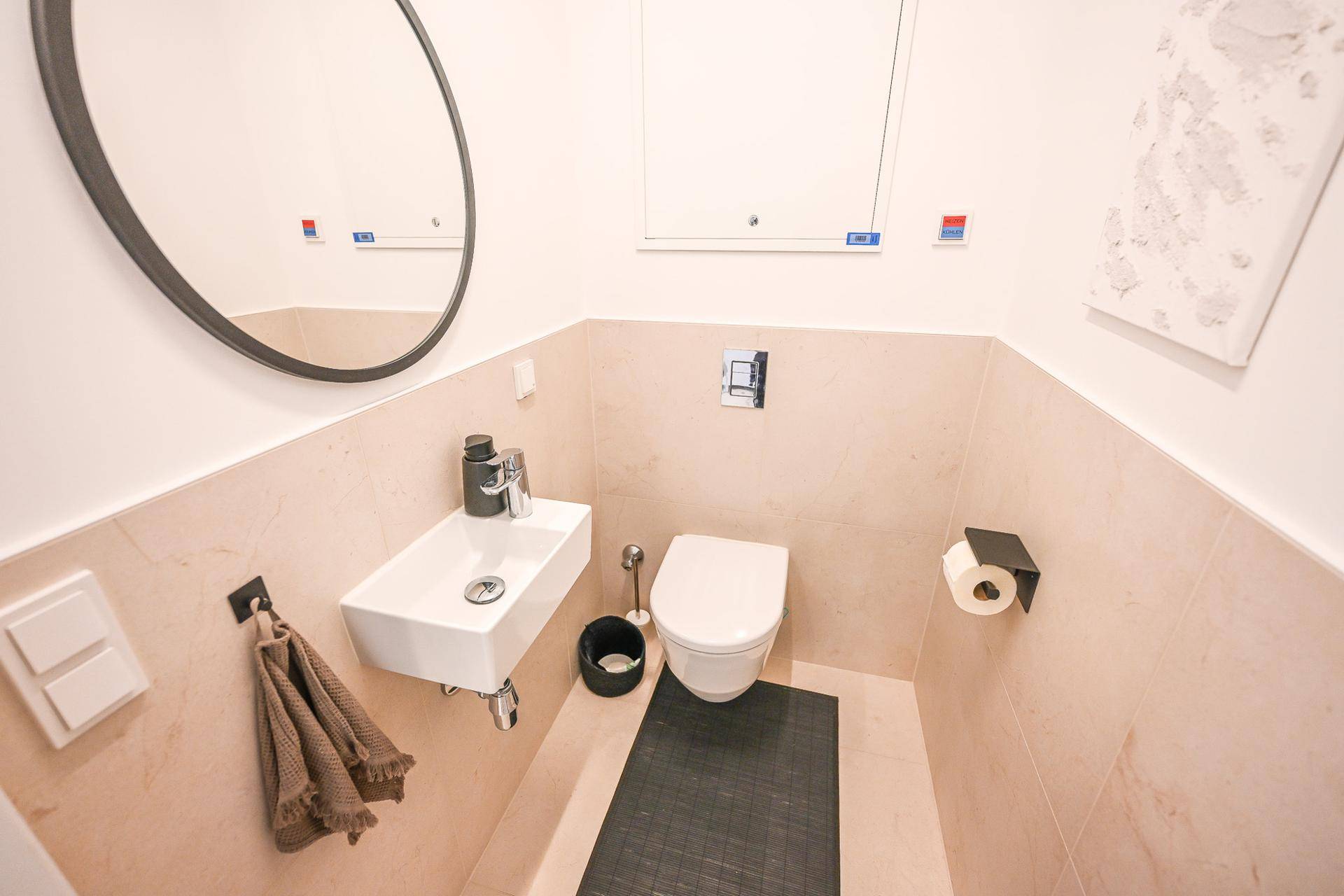 Kleines Gäste-WC mit modernem Waschbecken und Wand-WC.