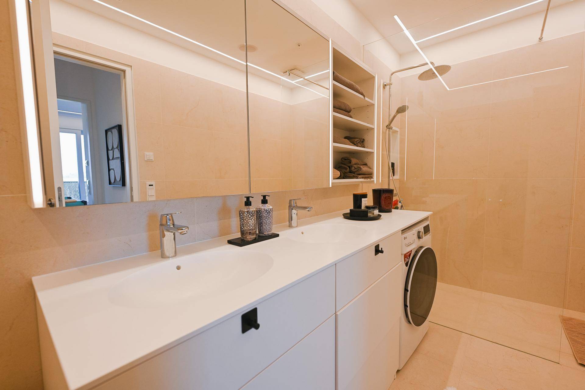 Helles Badezimmer mit Doppelwaschbecken, großer Dusche und modernen Armaturen.