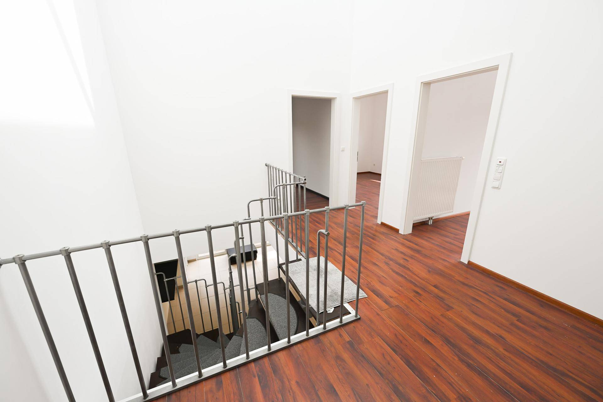 Heller Flur im Obergeschoss mit Laminatboden und Treppengeländer.