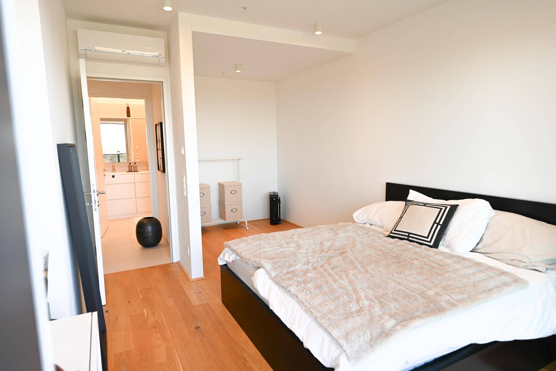 Schlafzimmer mit Zugang zum Badezimmer und Blick auf den Außenbereich.