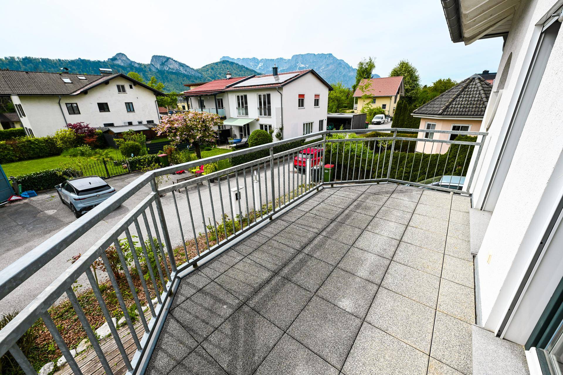Heller Balkon mit Fliesenboden und weitem Blick auf die Berge und Umgebung.