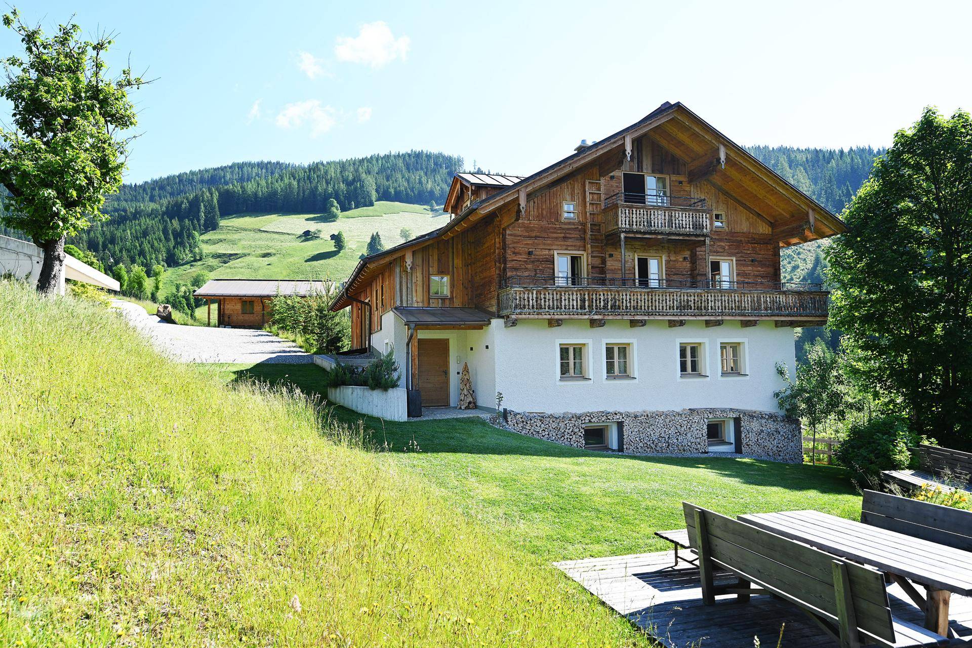 Charmantes Chalet mit traditioneller Holzfassade und einer einladenden Terrasse im Grünen.