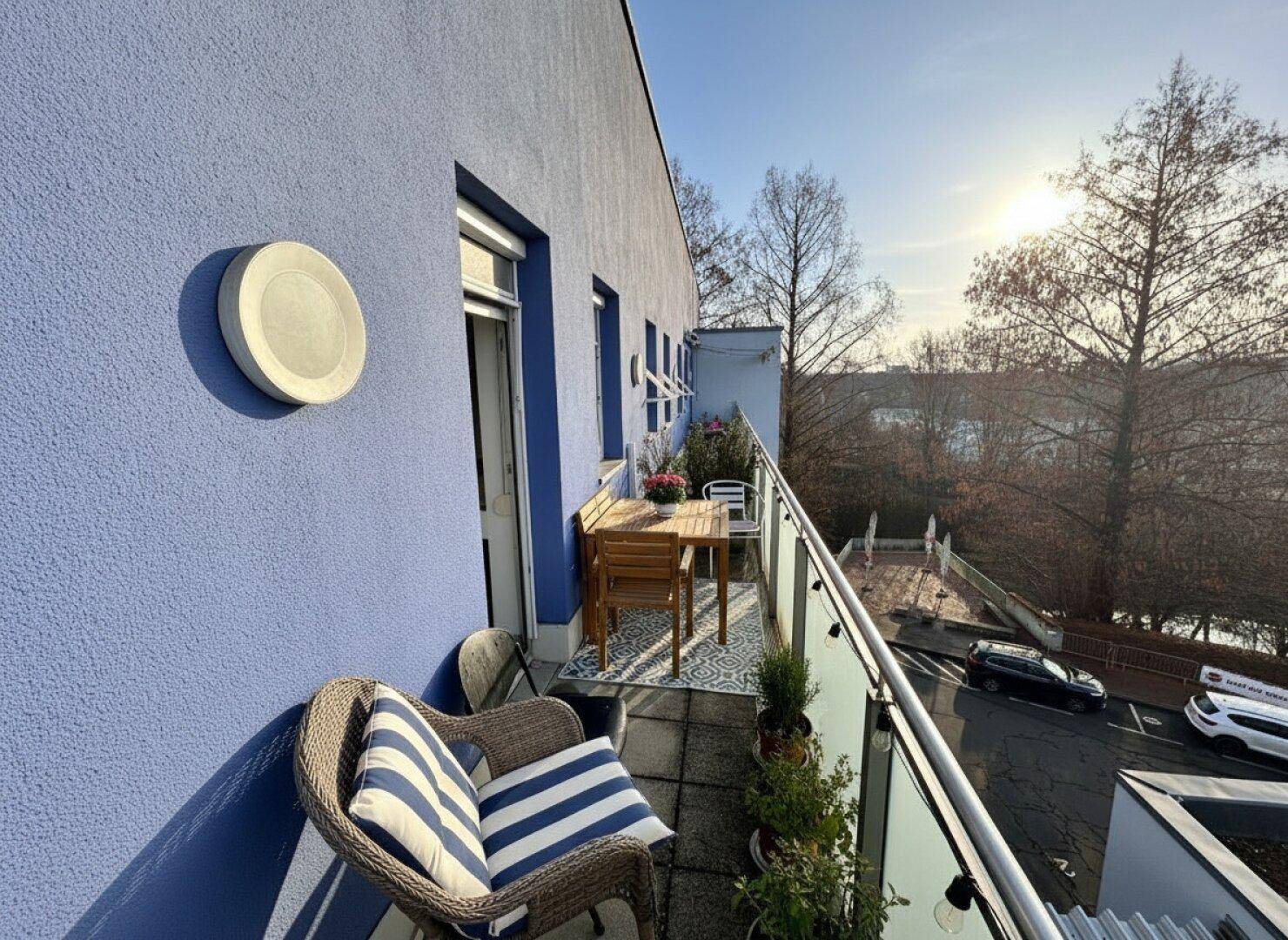 Gemütlicher Balkon mit Sitzgelegenheiten, einem Holztisch und einem schönen Blick auf die Umgebung.