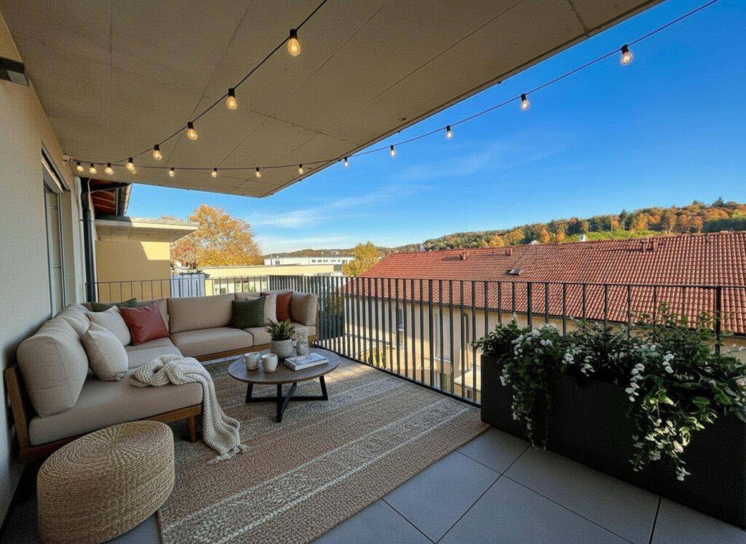 Gemütlicher Balkon mit Sitzgelegenheiten, Lichterkette und Blick auf die Umgebung.