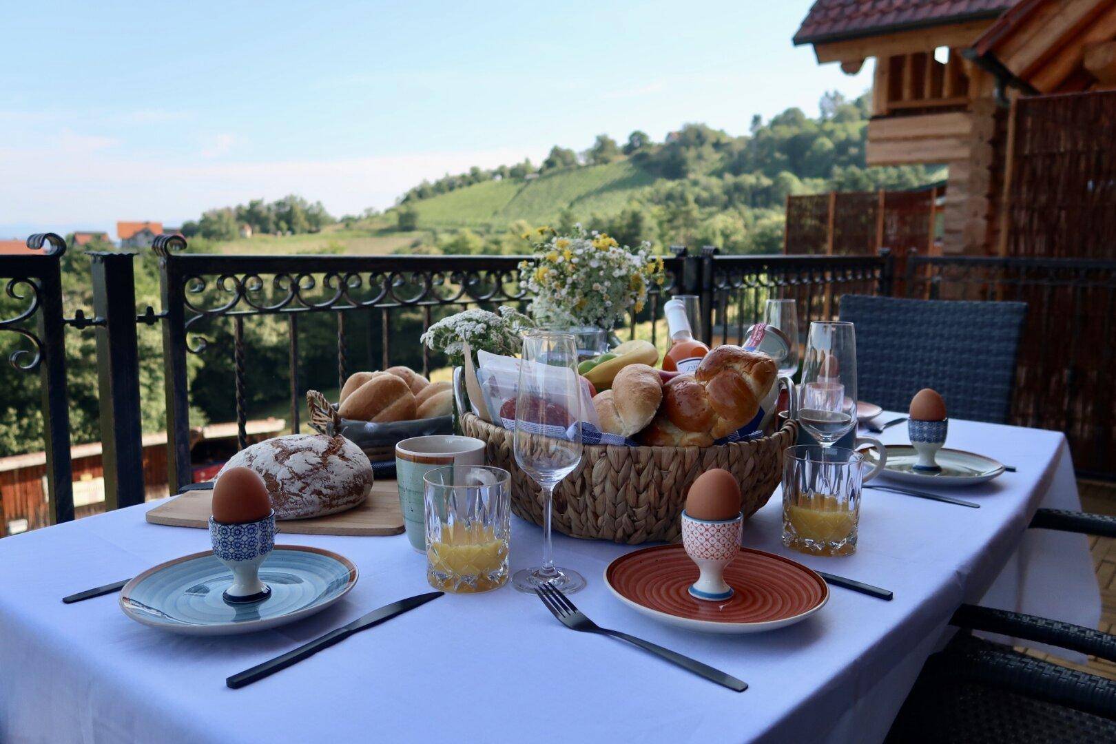 Einladender Balkon mit Frühstückstisch und malerischem Blick auf die umliegenden Weinberge und Hügel.
