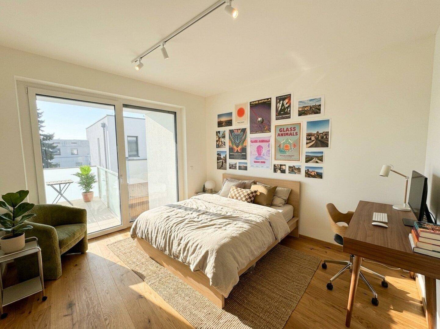 Sonnig helles Schlafzimmer mit Schreibtisch und direktem Zugang zum Balkon.