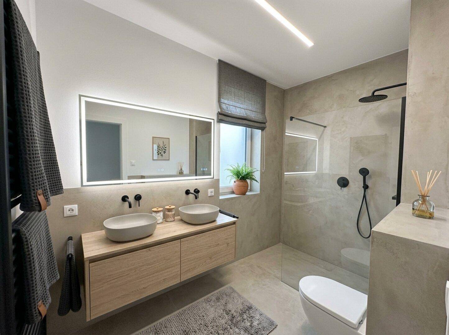 Modernes Badezimmer mit Doppelwaschbecken, begehbarer Dusche und Fenster.