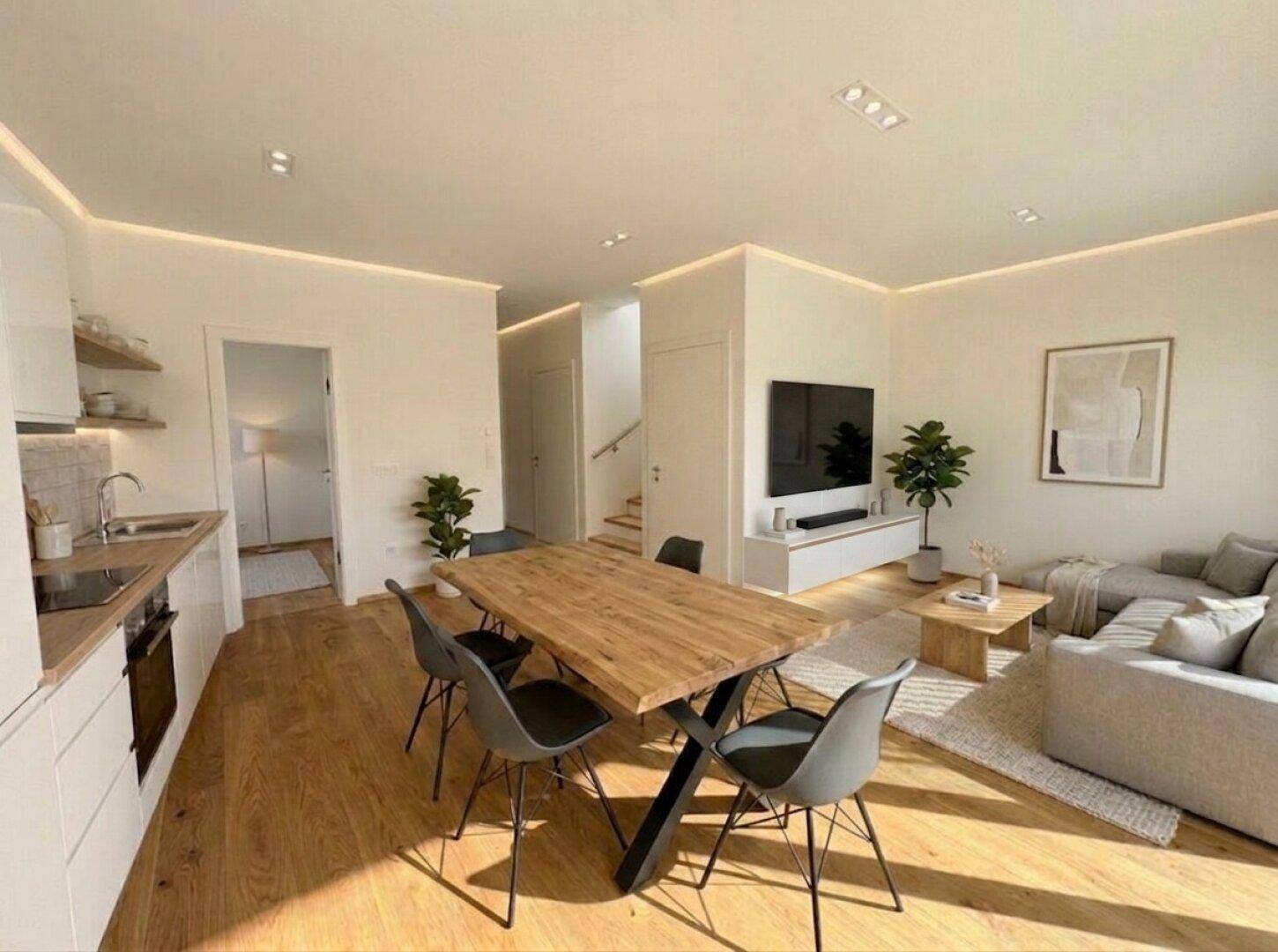 Offener Wohnbereich mit Essplatz und integrierter Küche, ideal für geselliges Beisammensein.
