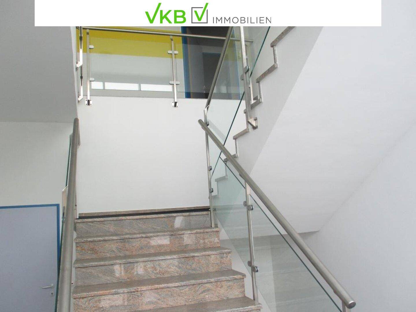 Moderner Treppenaufgang mit Granitstufen und elegantem Glas-Edelstahl-Geländer, hell und offen.