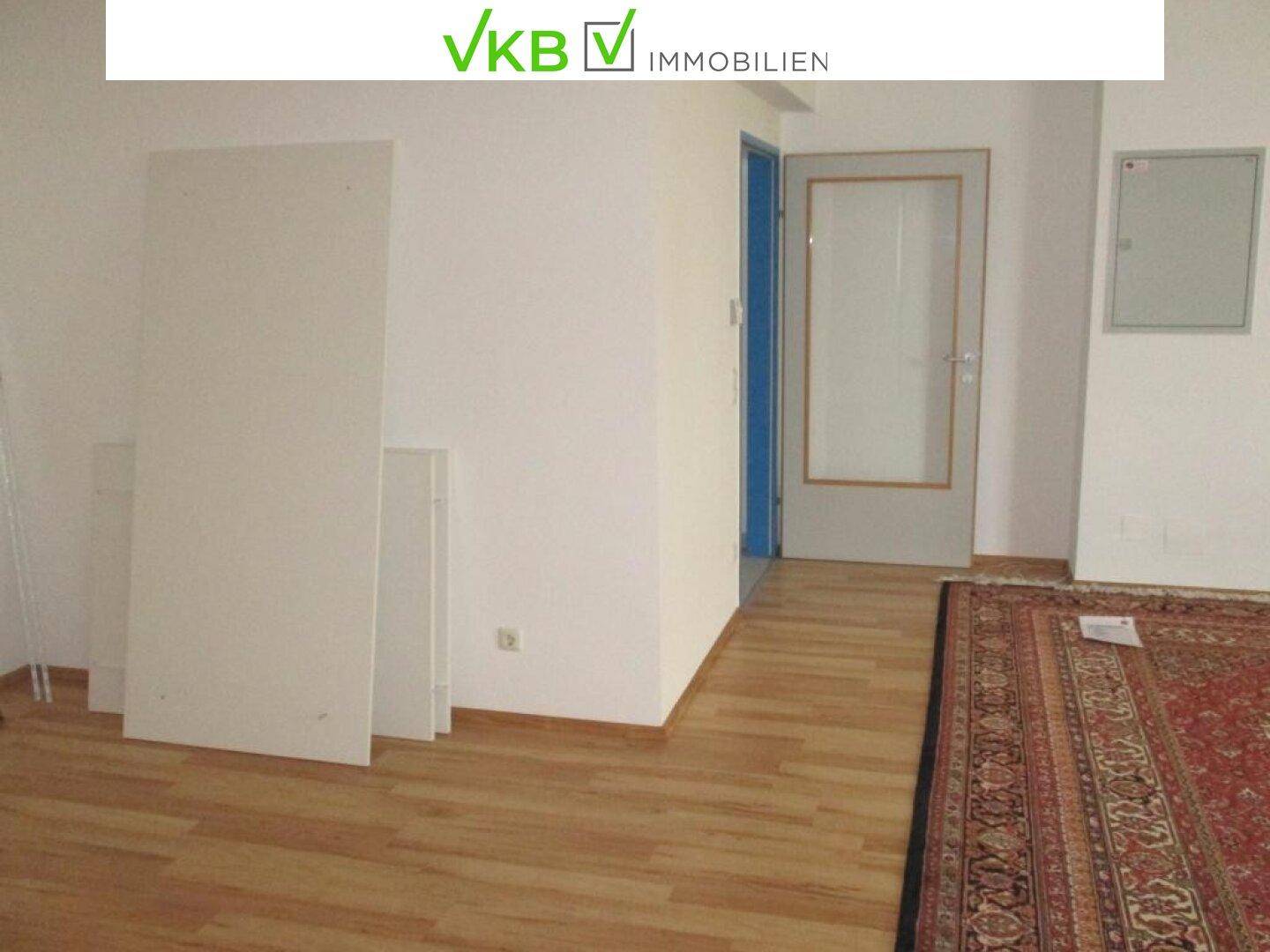Büroraum mit Laminatboden und einem roten Teppich, der einen Teil des Bodens bedeckt.