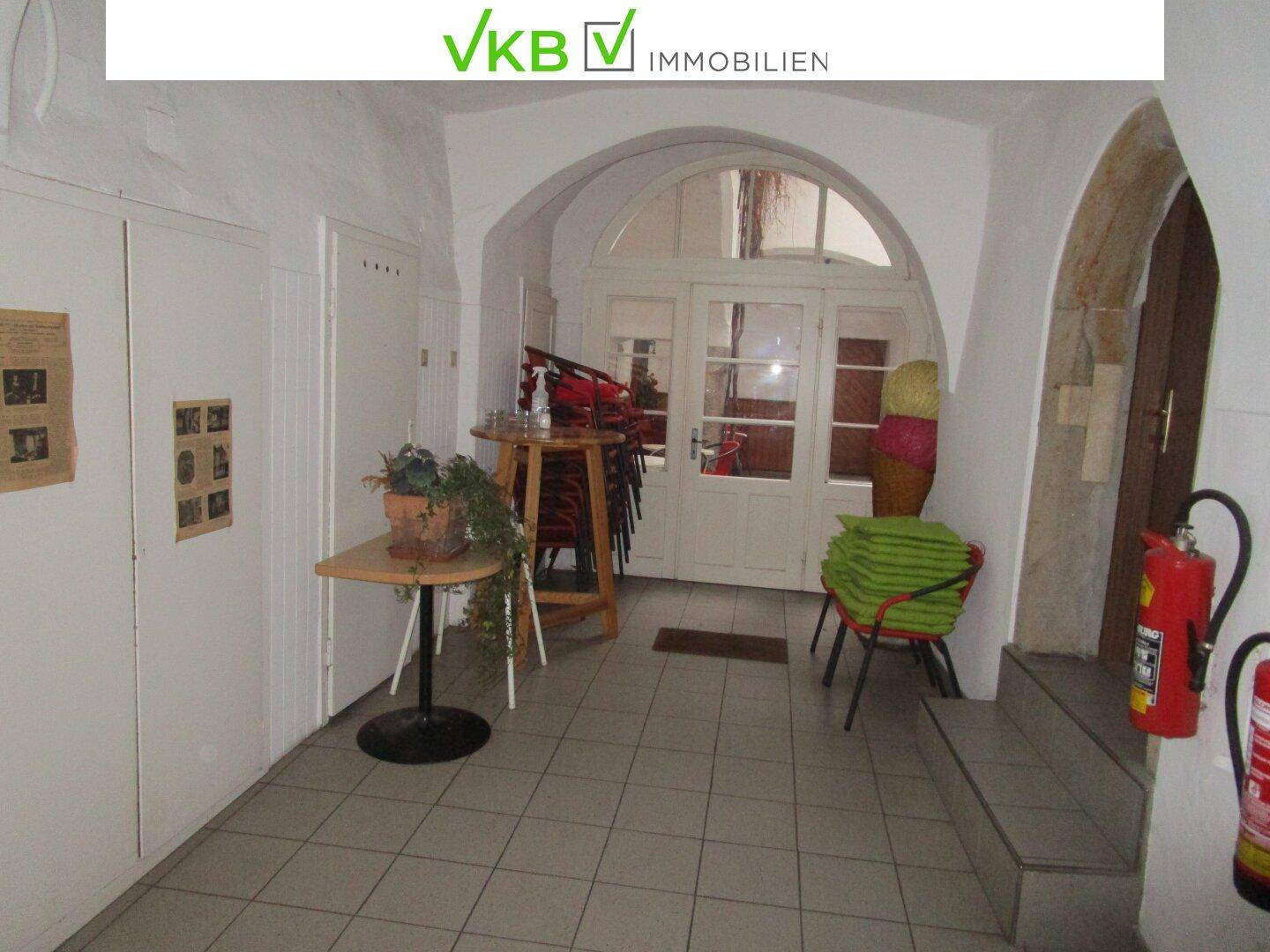 Geräumiger Eingangsbereich mit gefliestem Boden, gewölbter Decke und historischem Charme.