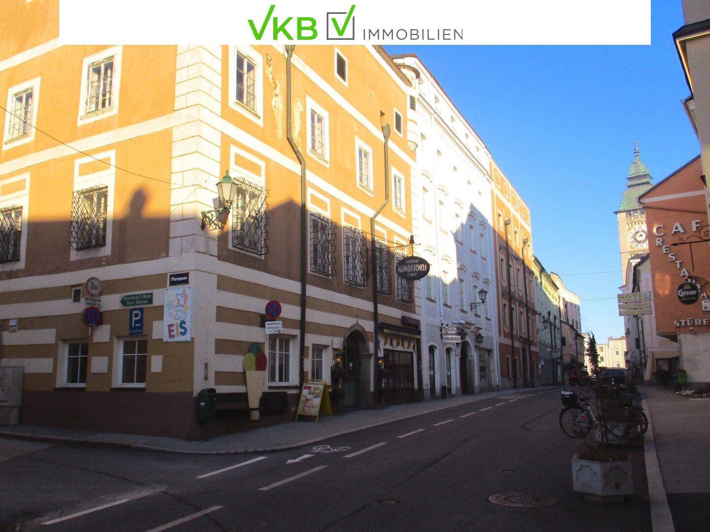 Historisches Gebäude an einer Straßenecke mit markanter orange-weißer Fassade und Blick auf die Gasse.