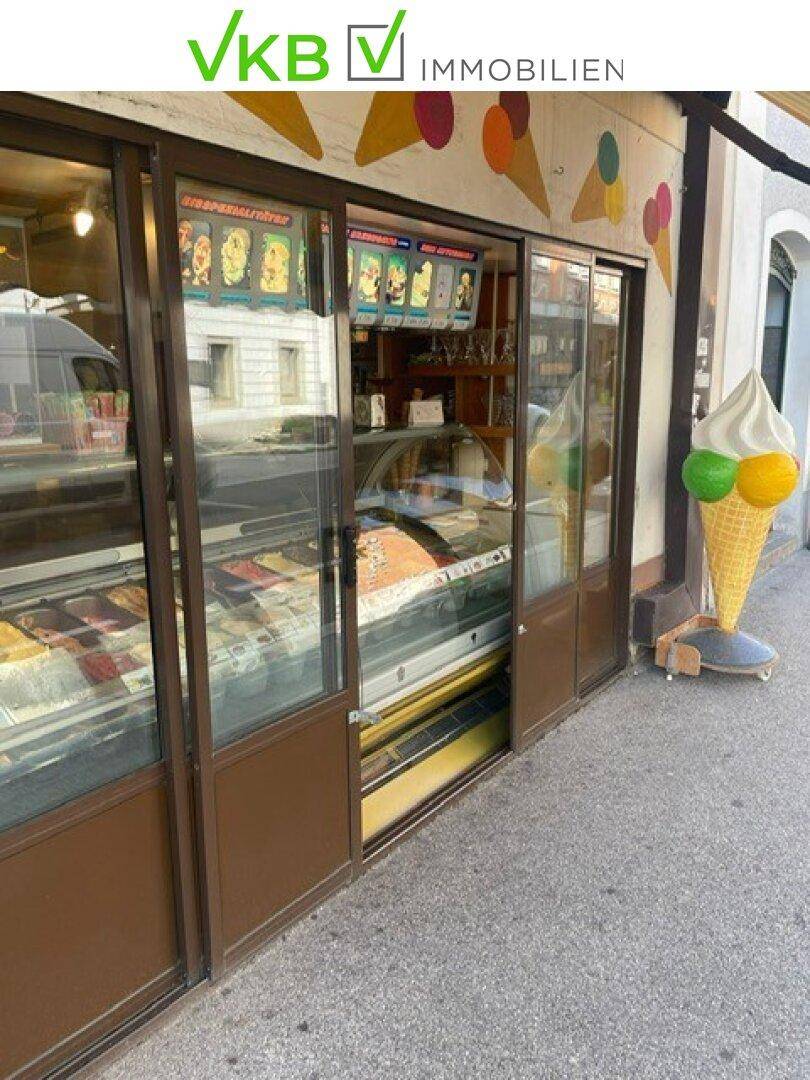 Außenansicht eines Eiscafés mit großen Schaufenstern und einer dekorativen Eistüte am Eingang.
