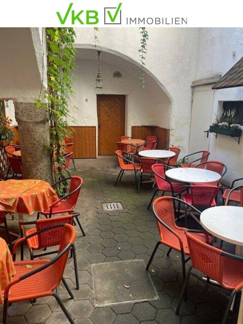 Ruhiger Innenhof mit zahlreichen Tischen und Stühlen, ideal für Gäste im Freien.