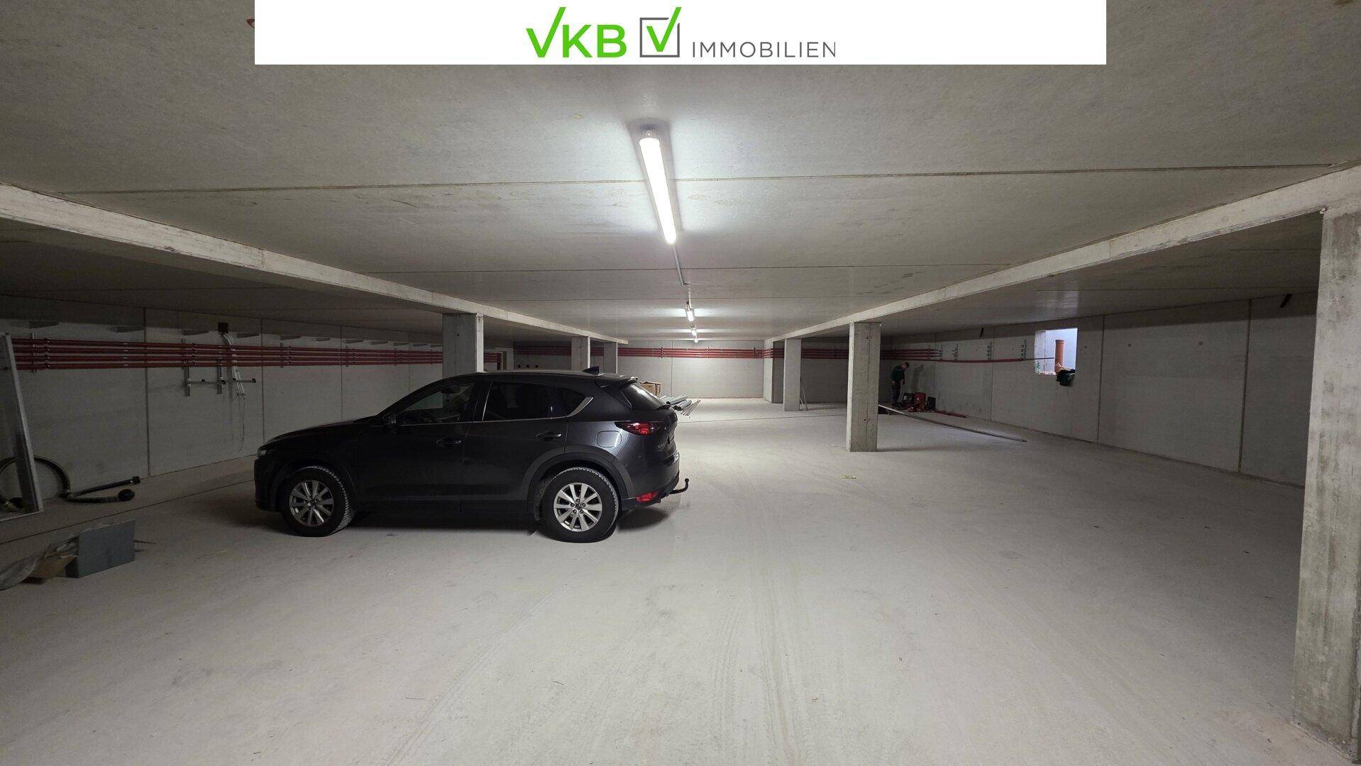 Geräumige Tiefgarage mit Betonboden und einem geparkten Fahrzeug.