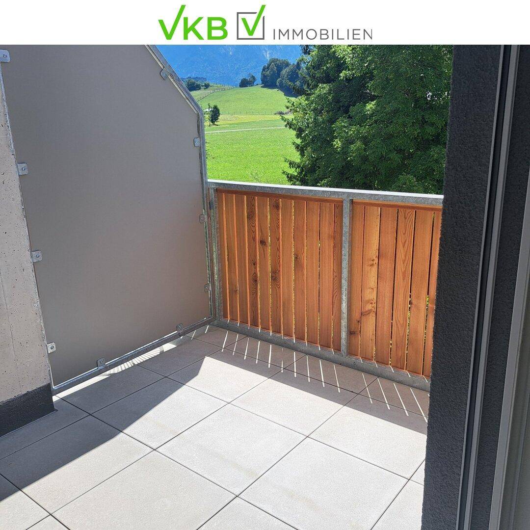 Sonniger Balkon mit Fliesenboden und Holzelementen, ideal zum Entspannen im Freien.