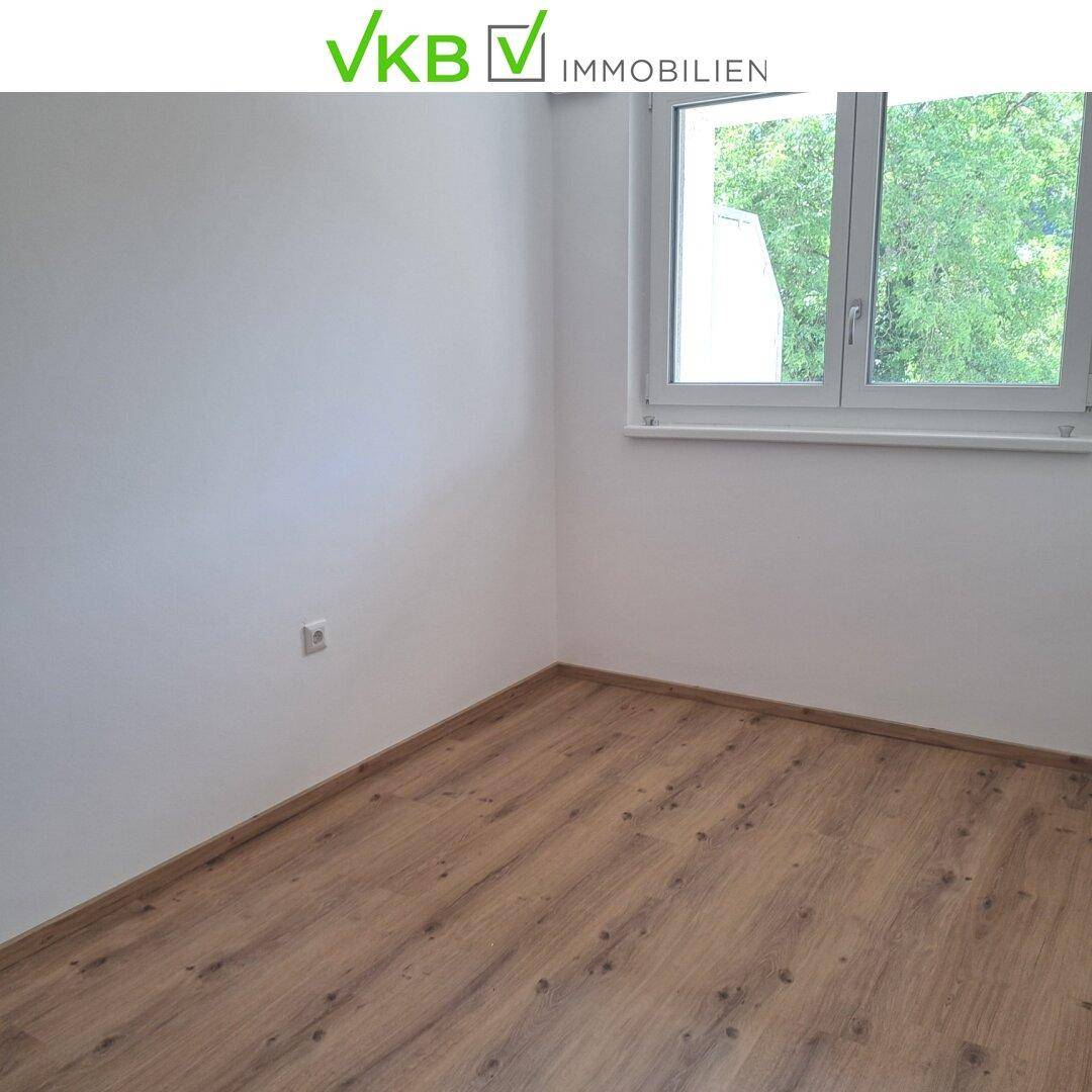 Leerer Raum mit Laminatboden und Fenster, bietet vielseitige Nutzungsmöglichkeiten.