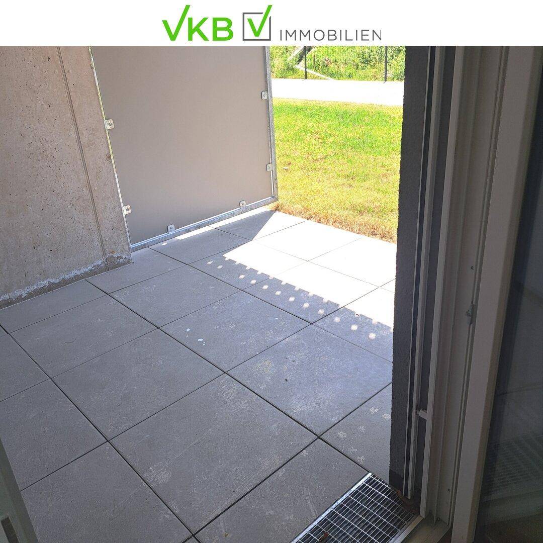 Kleine gepflasterte Terrasse im Erdgeschoss mit Zugang zum Gartenbereich.