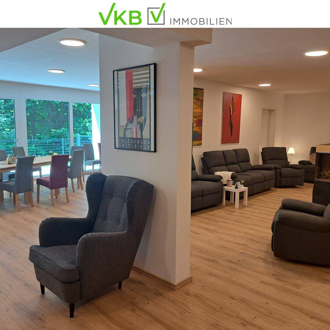 Großer Gemeinschaftsraum mit Sitzgelegenheiten und Essbereich, hell und modern eingerichtet.