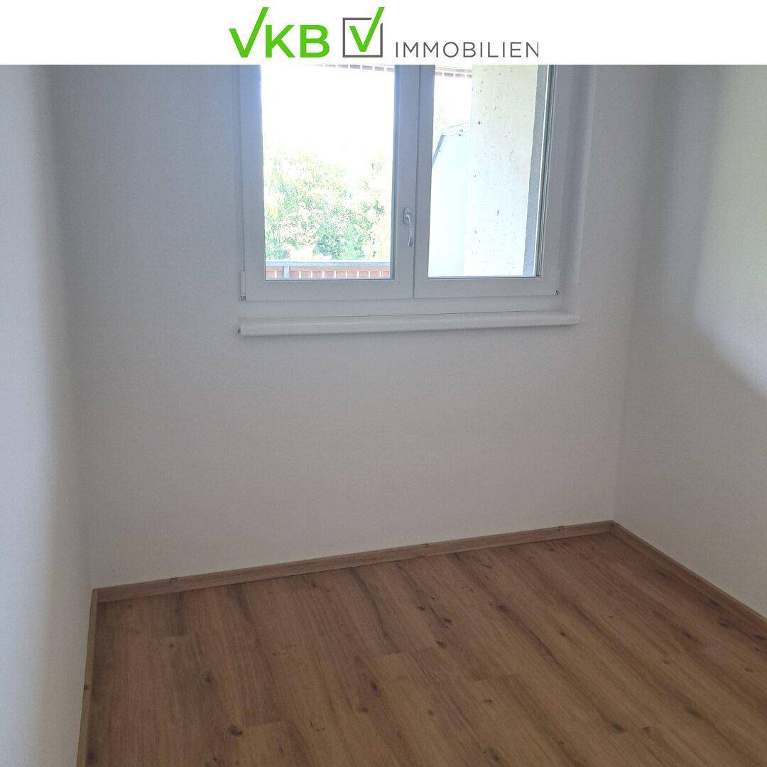 Kleiner, heller Raum mit Laminatboden und Fenster, ideal als Arbeits- oder Kinderzimmer.