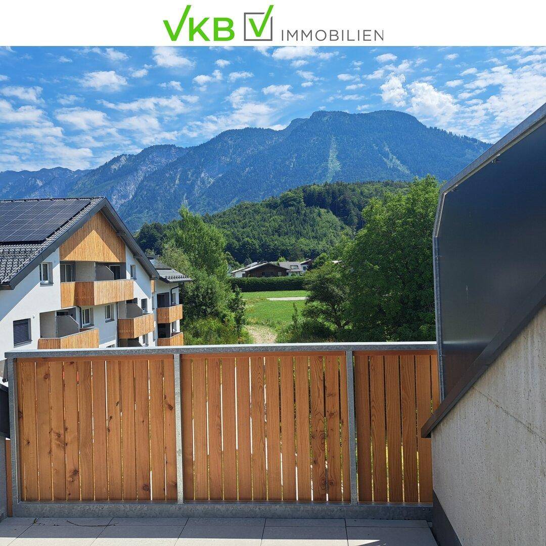 Balkon mit Holzzaun und beeindruckendem Blick auf die umliegende Berglandschaft.