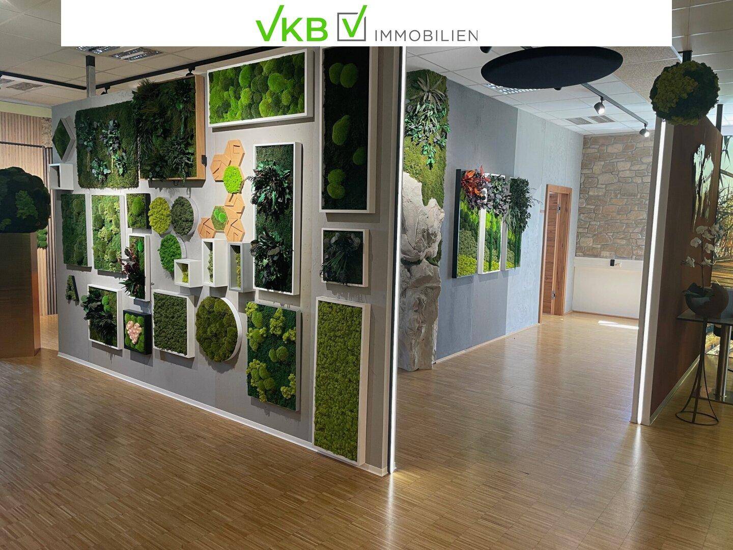 Flur mit einer beeindruckenden Wanddekoration aus verschiedenen Moosbildern und hellem Holzboden.