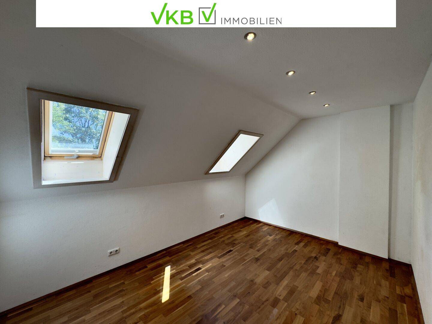 Gemütliches Schlafzimmer im Dachgeschoss mit Holzboden und zwei Dachfenstern für viel Licht.