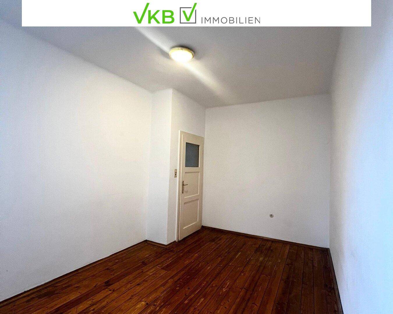 Schlichtes Zimmer mit Dielenboden und weiß gestrichenen Wänden, ideal für verschiedene Nutzungen.
