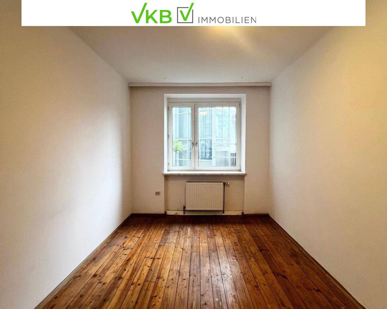 Lichtdurchflutetes Zimmer mit breiten Dielen und einem großen Fenster, das eine helle Atmosphäre schafft.