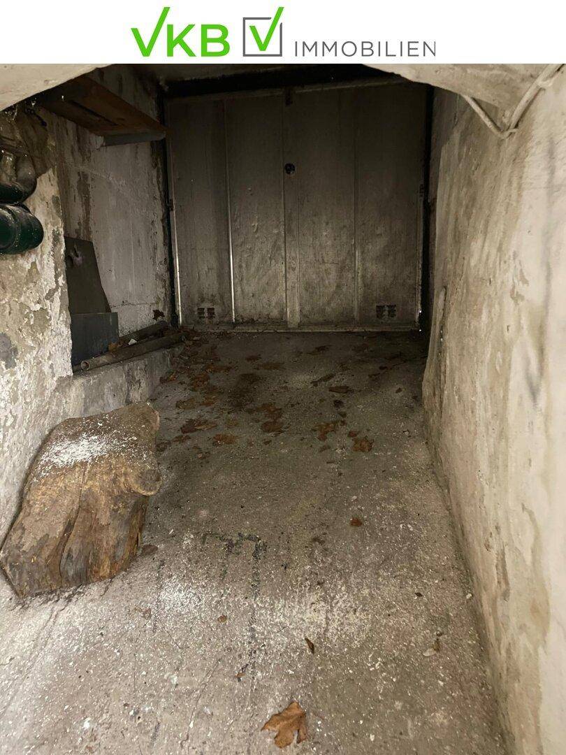 Leerer Kellerraum mit Betonboden und Spuren von Laub, der als Abstellfläche genutzt werden könnte.