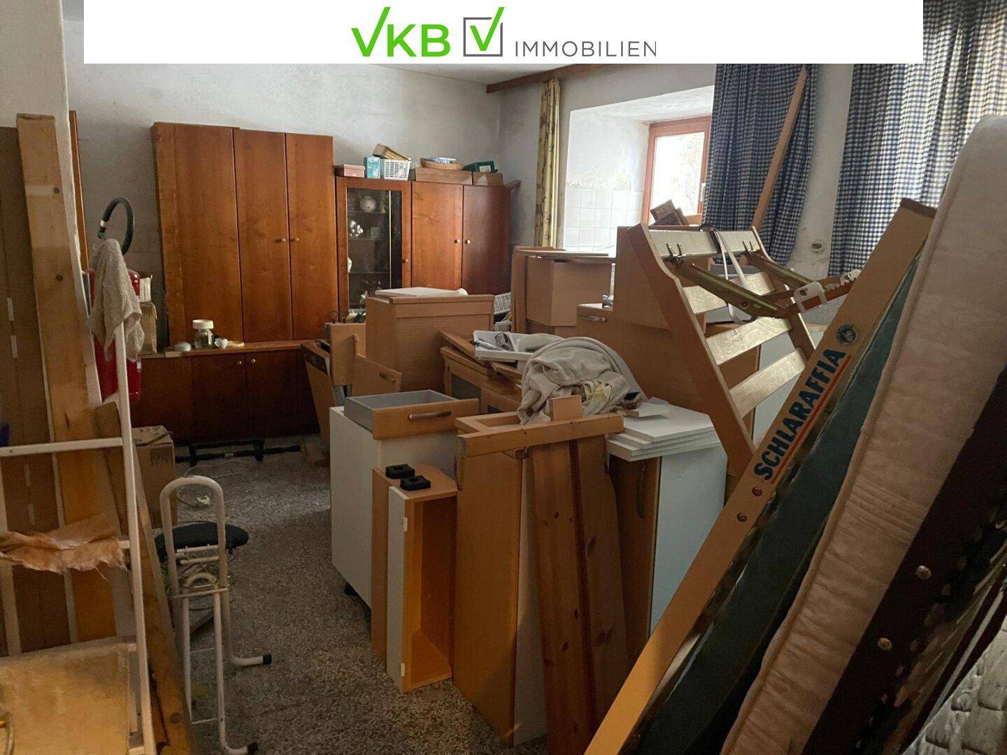 Überfüllter Abstellraum mit Möbeln, Kisten und verschiedenen Gegenständen, die gelagert werden.