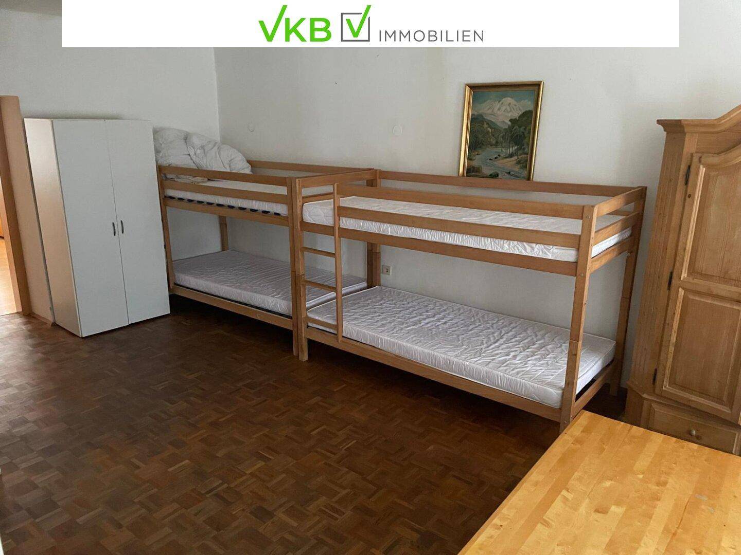 Geräumiges Schlafzimmer mit Holzboden und zwei Etagenbetten, ideal für mehrere Personen.