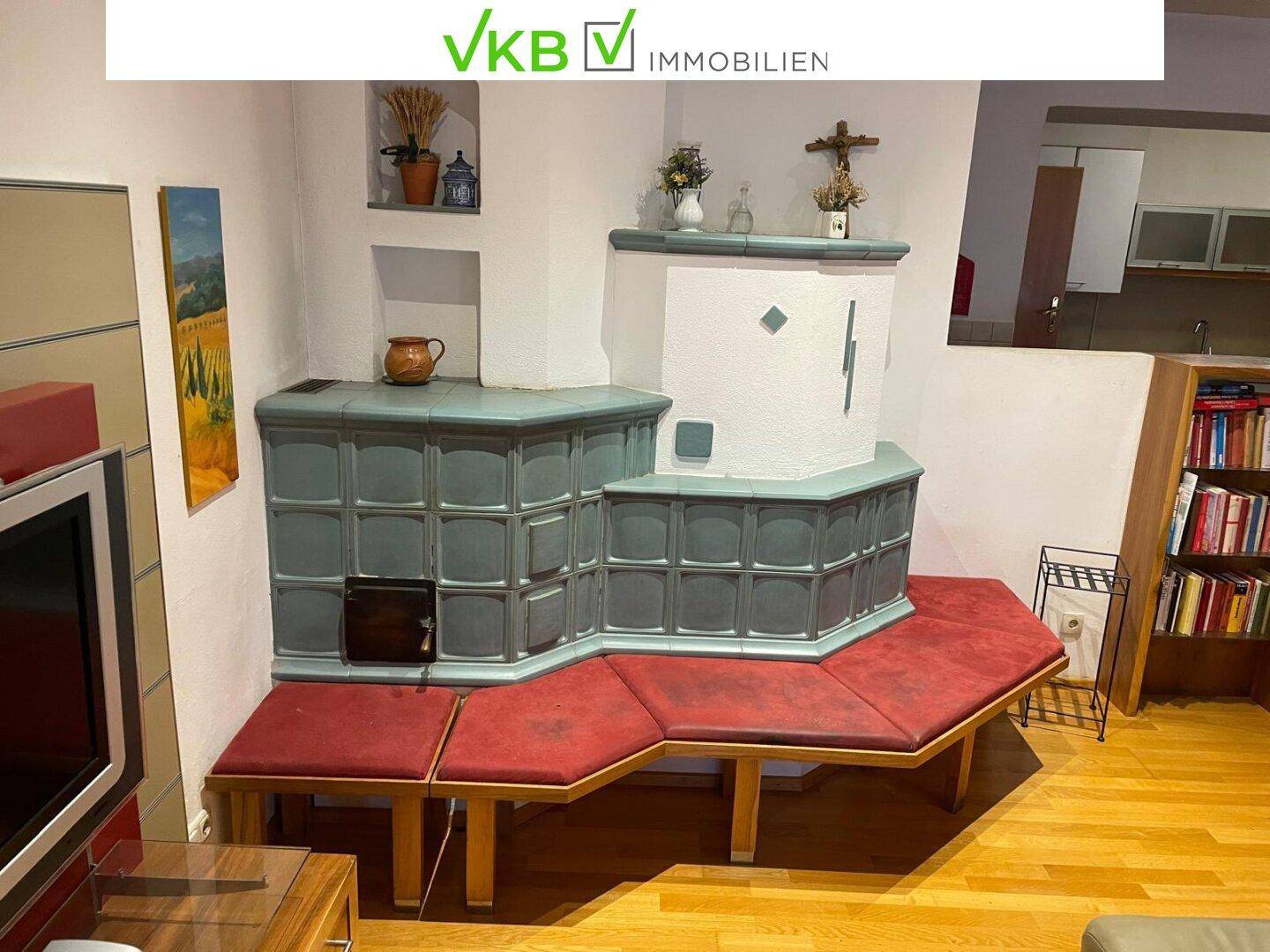 Gemütliches Wohnzimmer mit einem großen Kachelofen, Sitzbank und Holzboden, traditionell eingerichtet.