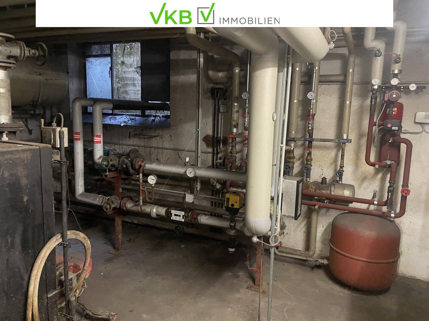 Heizungsraum mit komplexen Rohrleitungen, Kesseln und Pumpen, die die Gebäudetechnik versorgen.