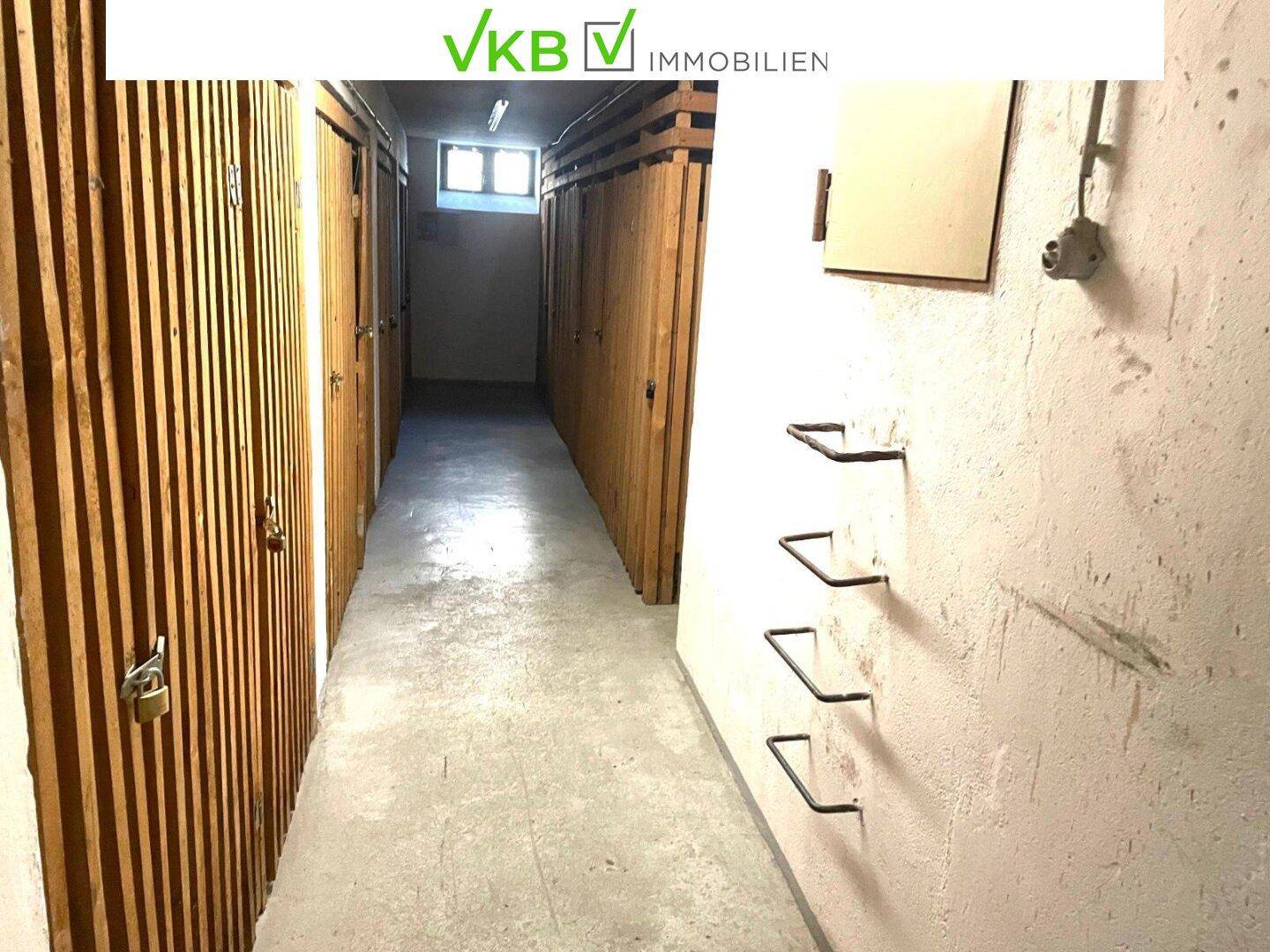 Kellerabteil mit Holzverschlägen und Betonboden für zusätzlichen Stauraum.