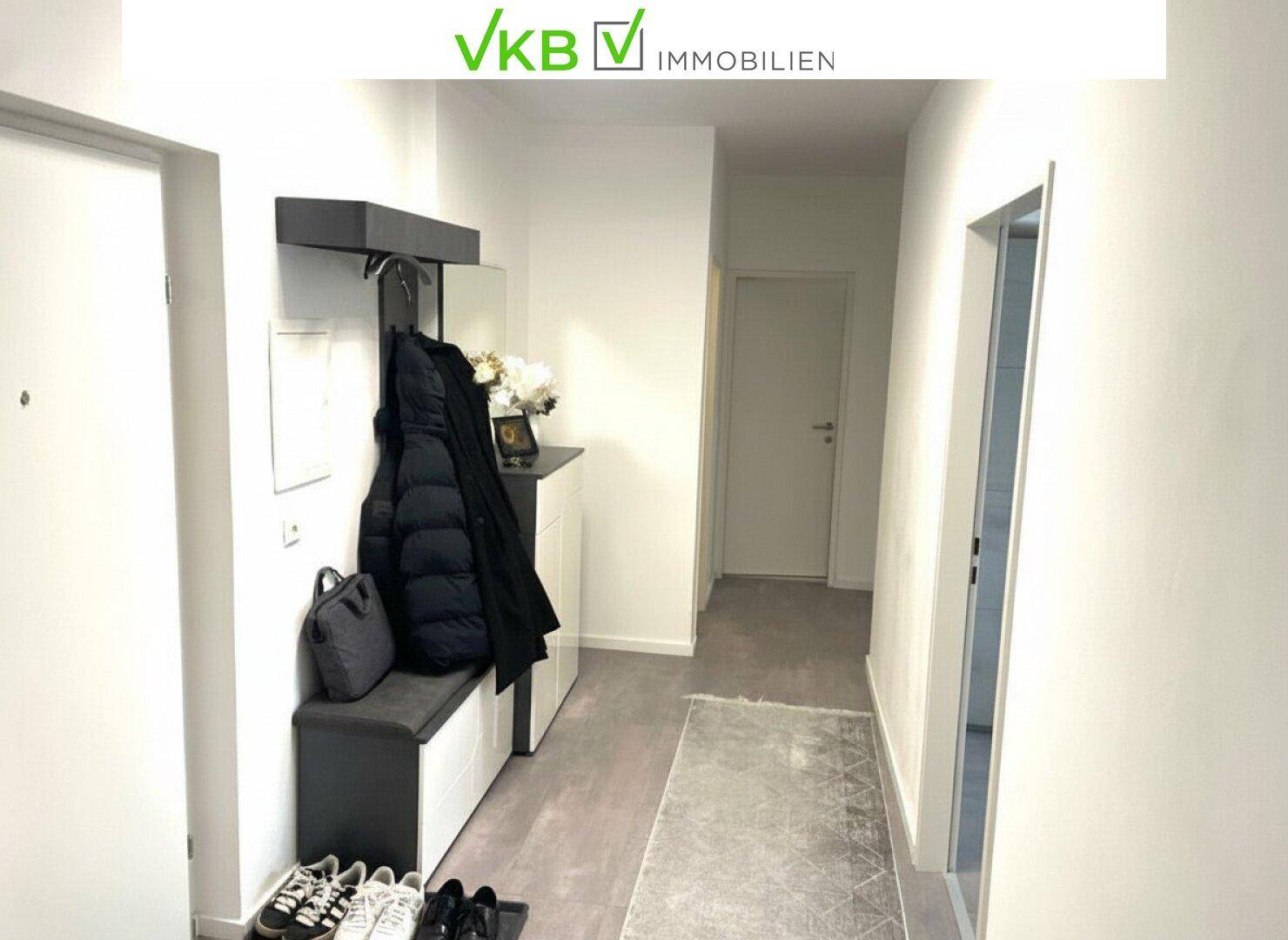 Moderner Eingangsbereich mit Garderobe, Schuhbank und hellem Boden.