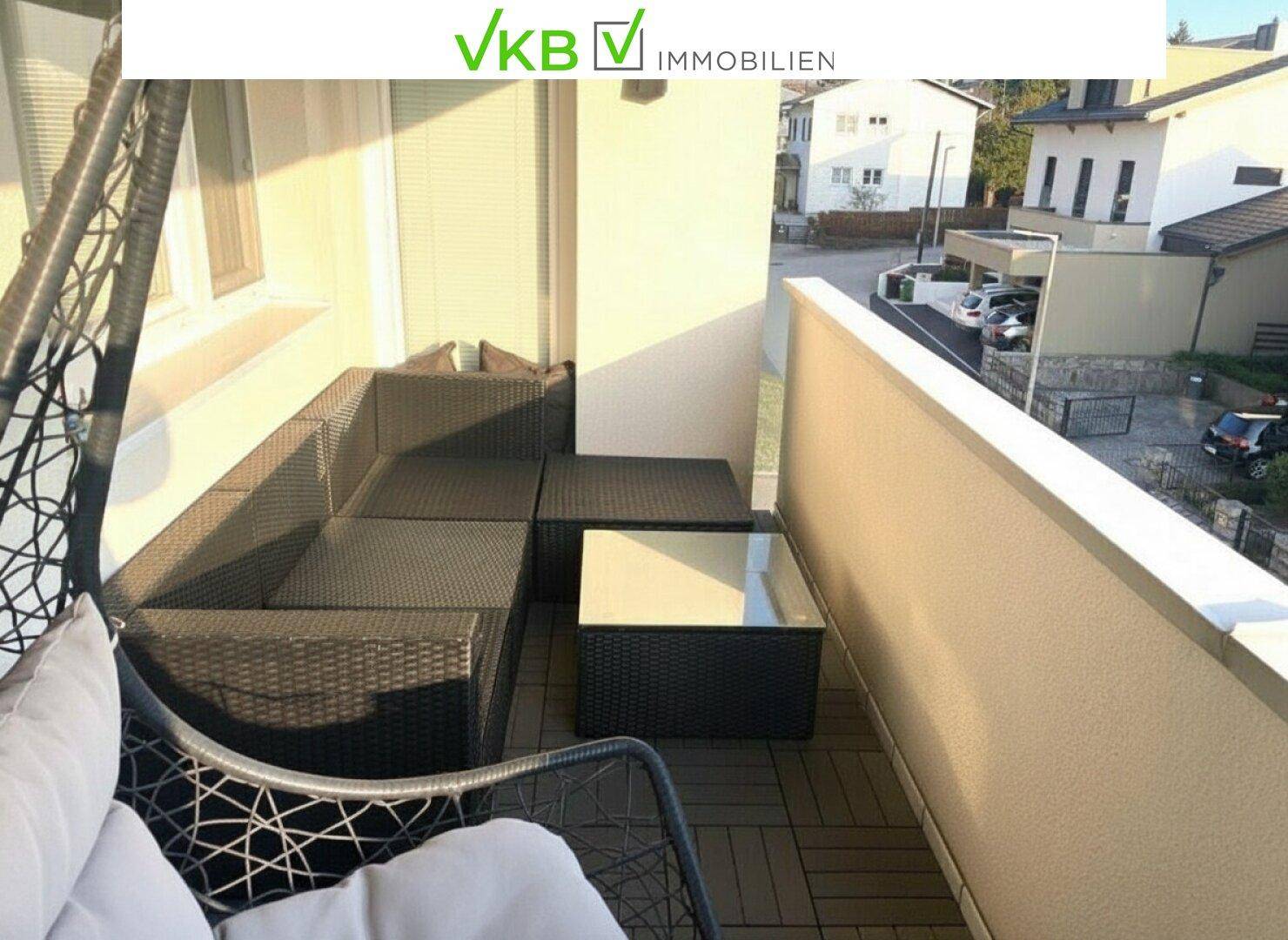 Möblierter Balkon mit bequemen Outdoor-Sitzgelegenheiten und Blick auf die Umgebung.
