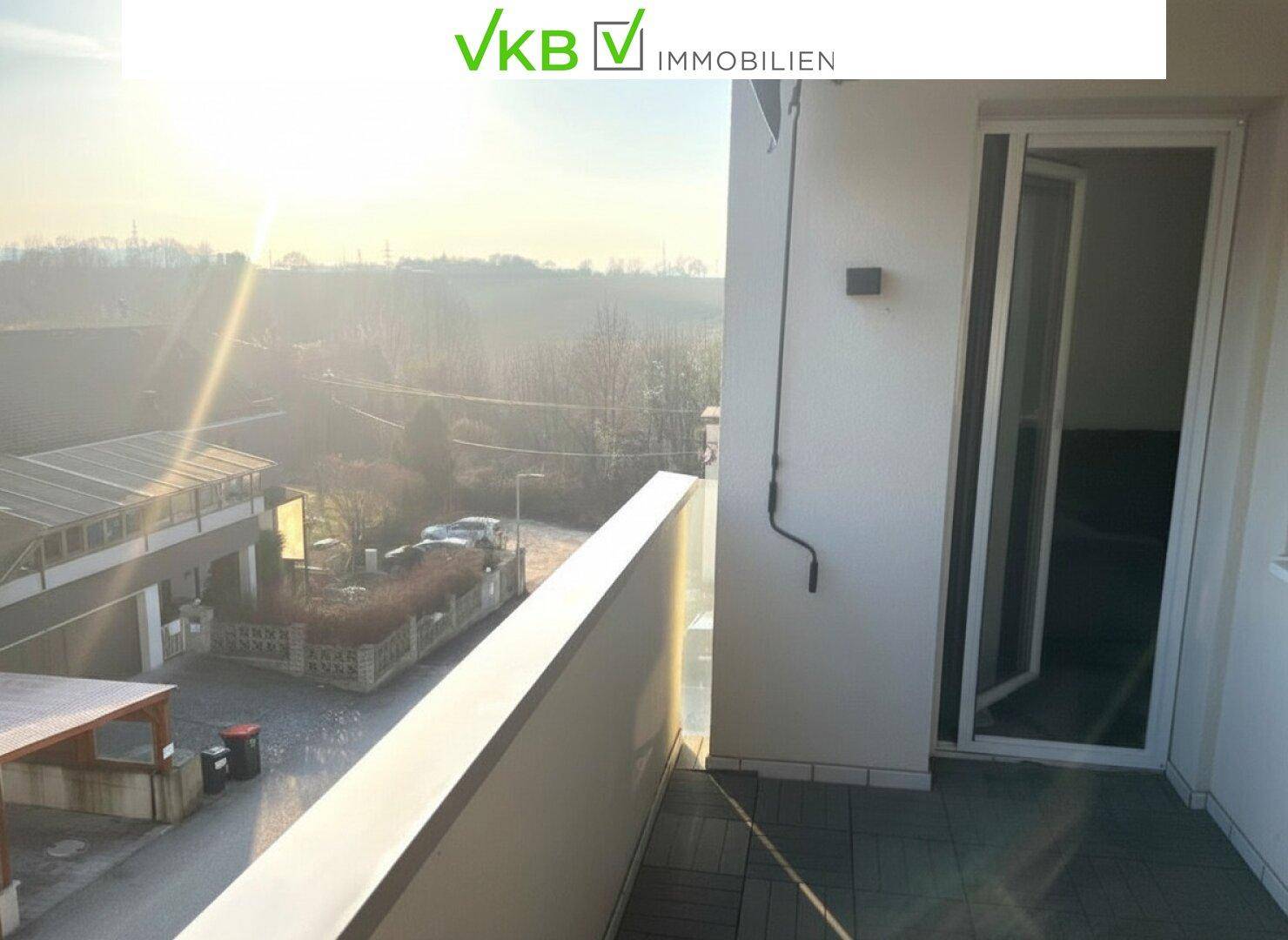 Balkonzugang mit Schiebetür und sonnigem Ausblick auf die Umgebung.