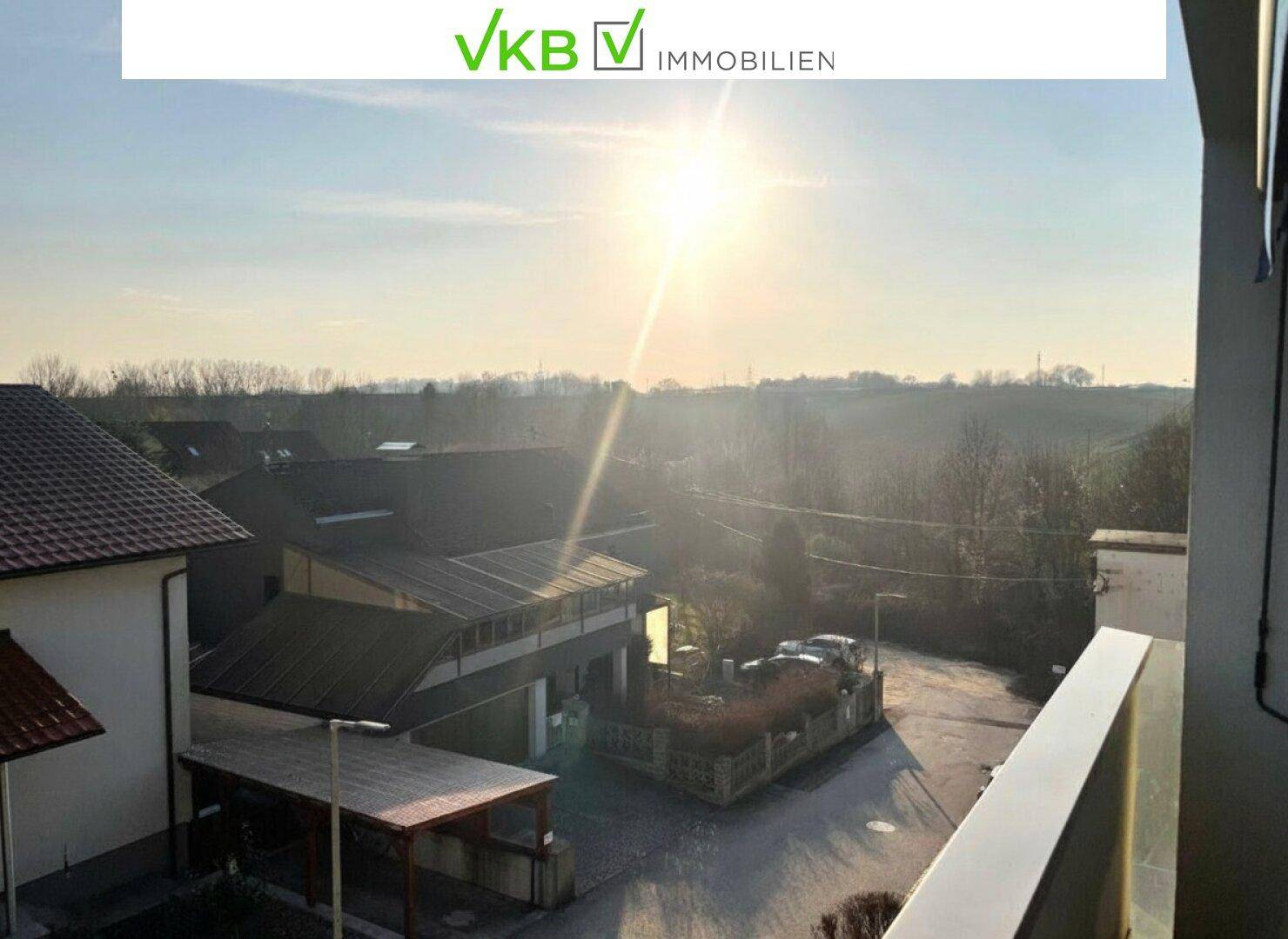 Sonniger Ausblick vom Balkon auf die umliegende Landschaft und Nachbarschaft.