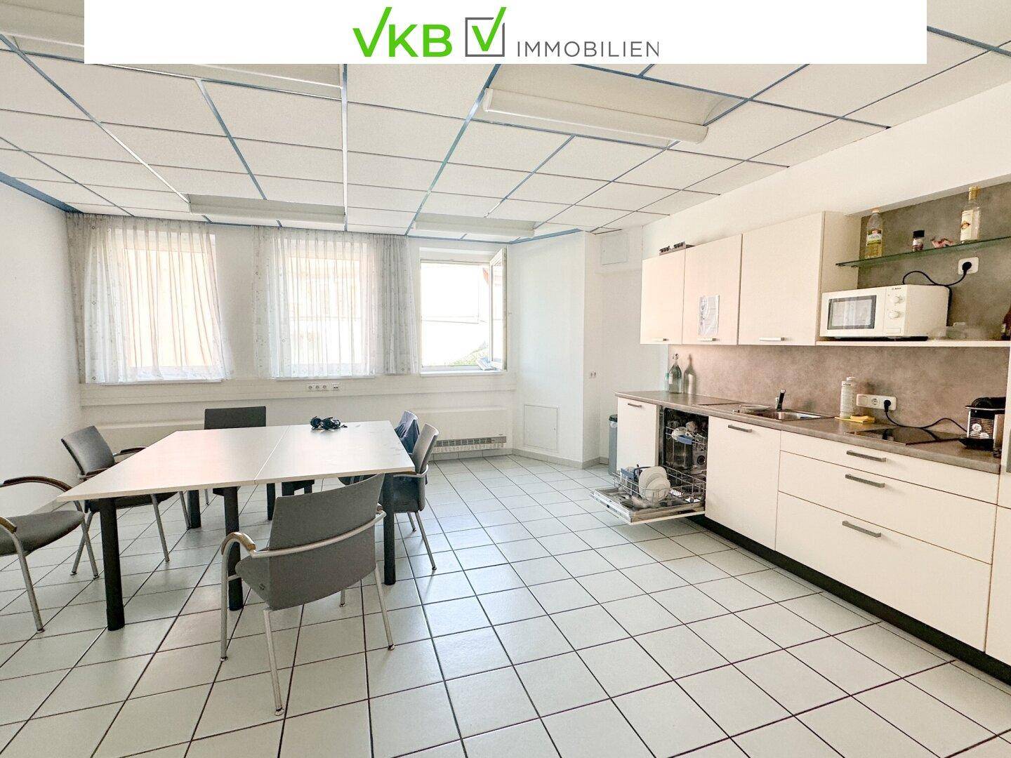Funktionale Küchenzeile mit Spülmaschine und Essbereich, ideal für Pausen im Bürogebäude.